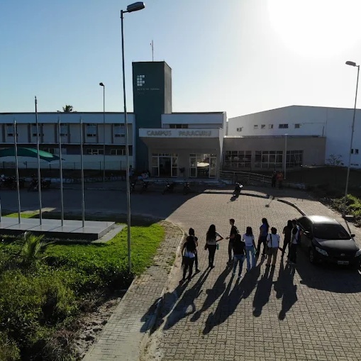 Fachada do campus Paracuru do IFCE, com estudantes caminhando no pátio de entrada
